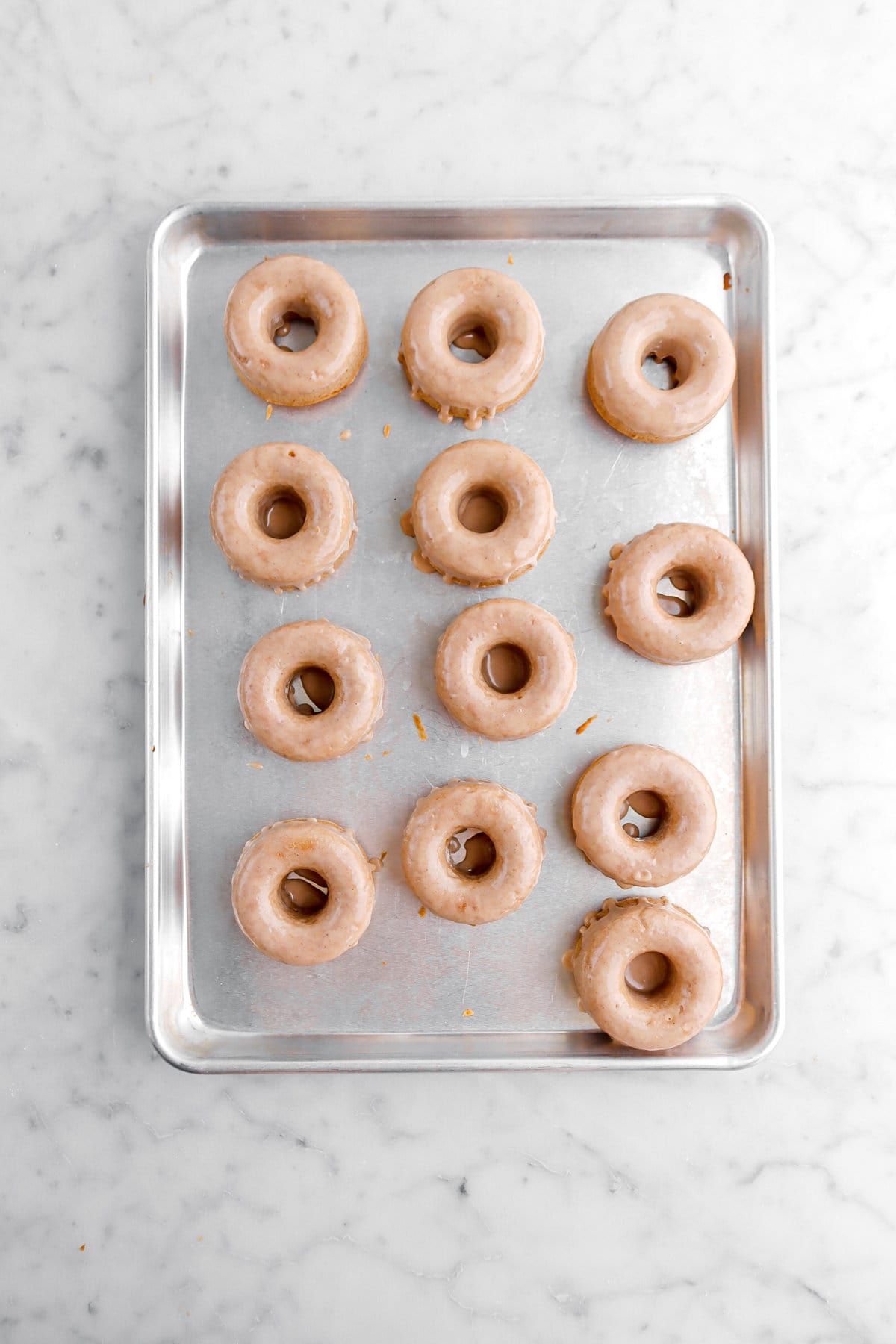 iced donuts on sheet pan.