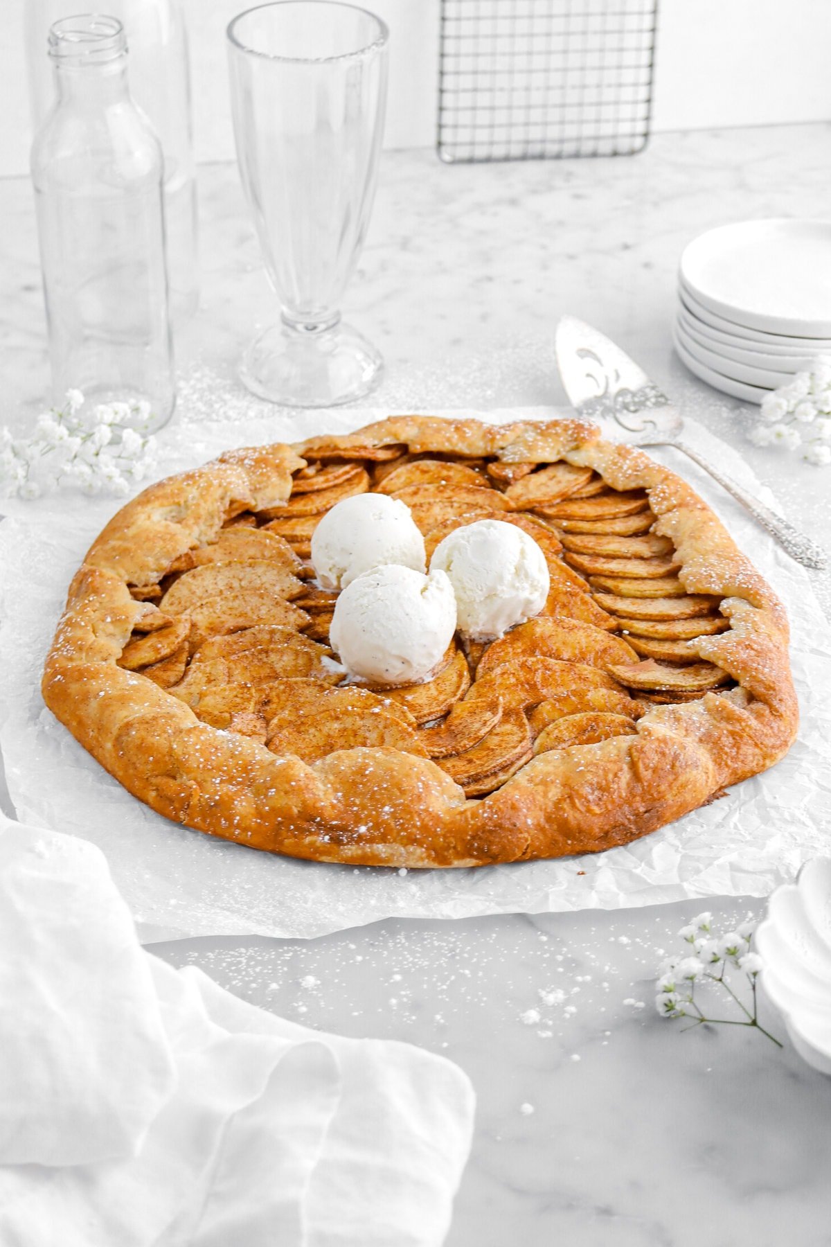 angled image of apple galette with three scoops of ice cream on top.
