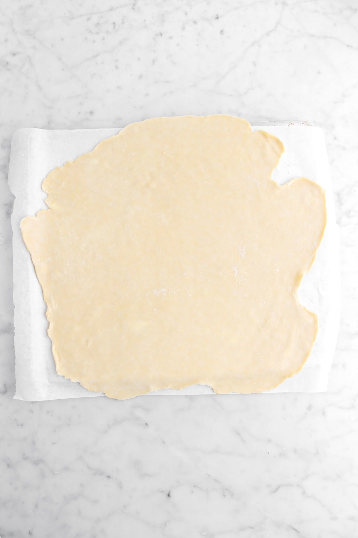 rolled out pie dough on parchment paper.