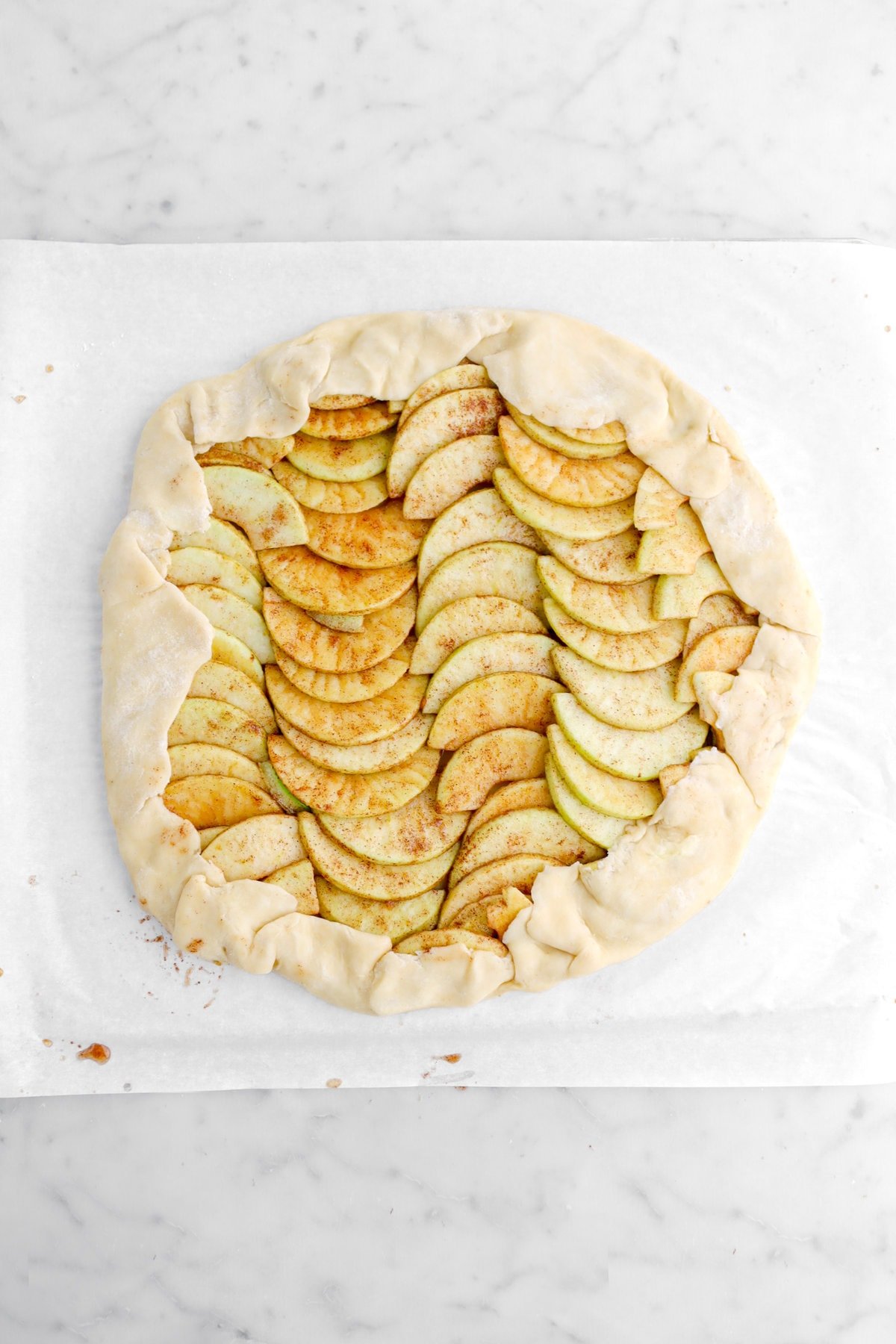 edges of pie dough folded over apple slices.