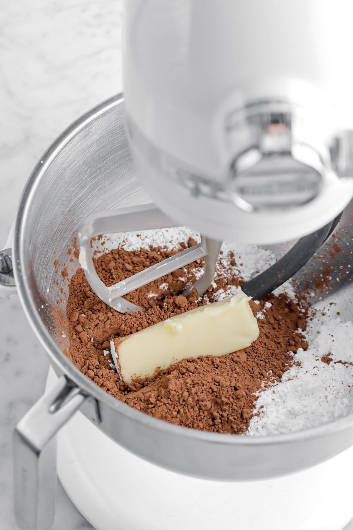 cocoa powder, butter, and powdered sugar in stand mixer.