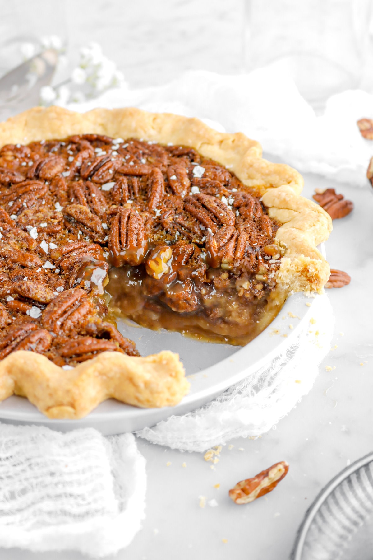 angled close up of cut maple pecan pie in metal pie pan.