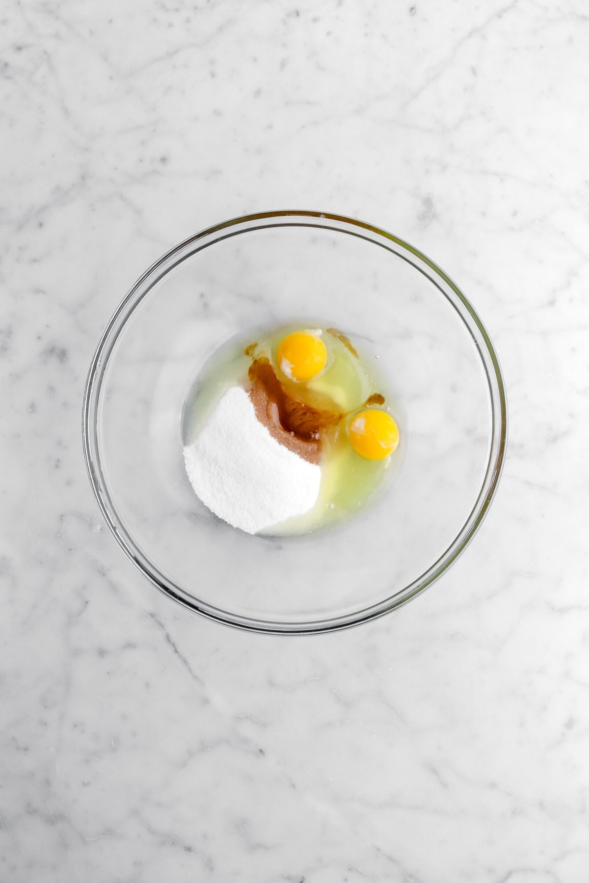 egg, vanilla, and sugar in glass bowl.