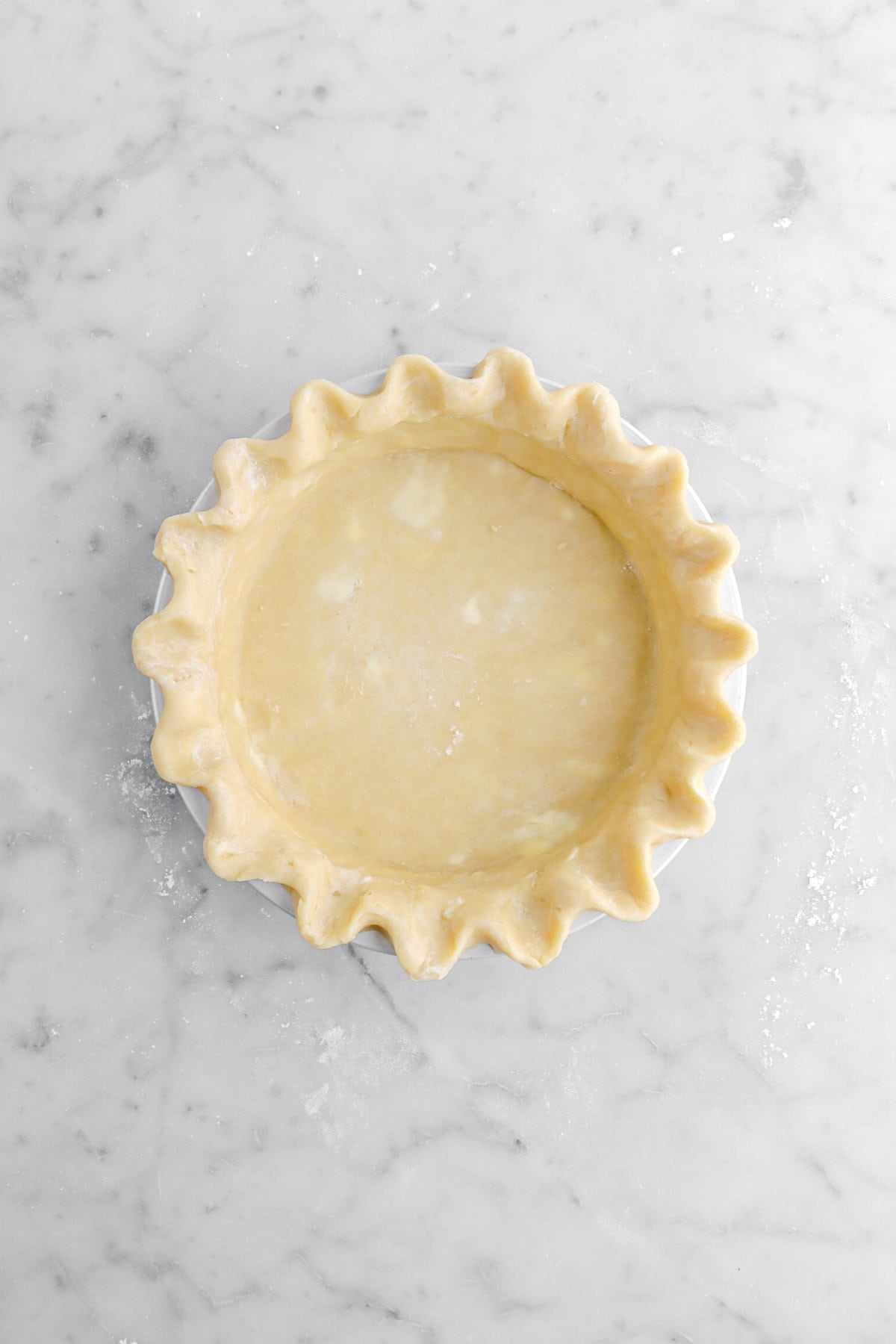 scalloped pie dough in metal pan.