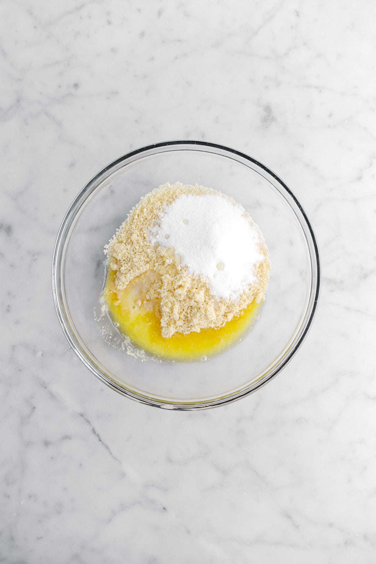 sugar, cookie crumbs, and butter in glass bowl.
