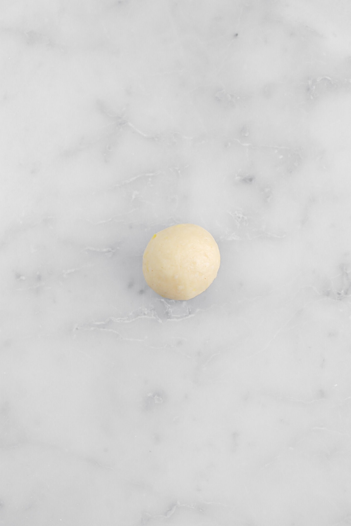 dough ball on marble surface.