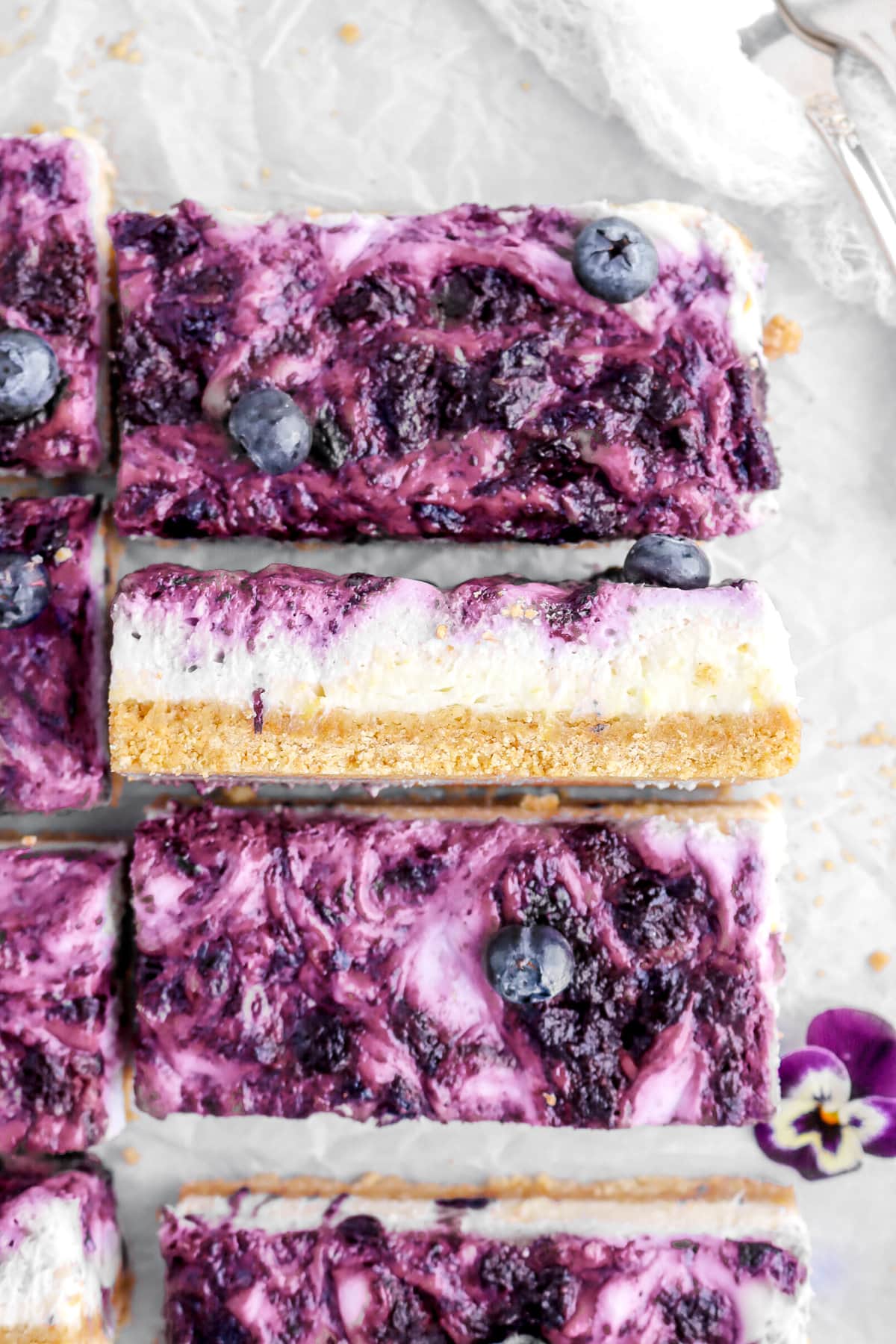 close up overhead image of lemon blueberry cheesecake bar turned on it's side.