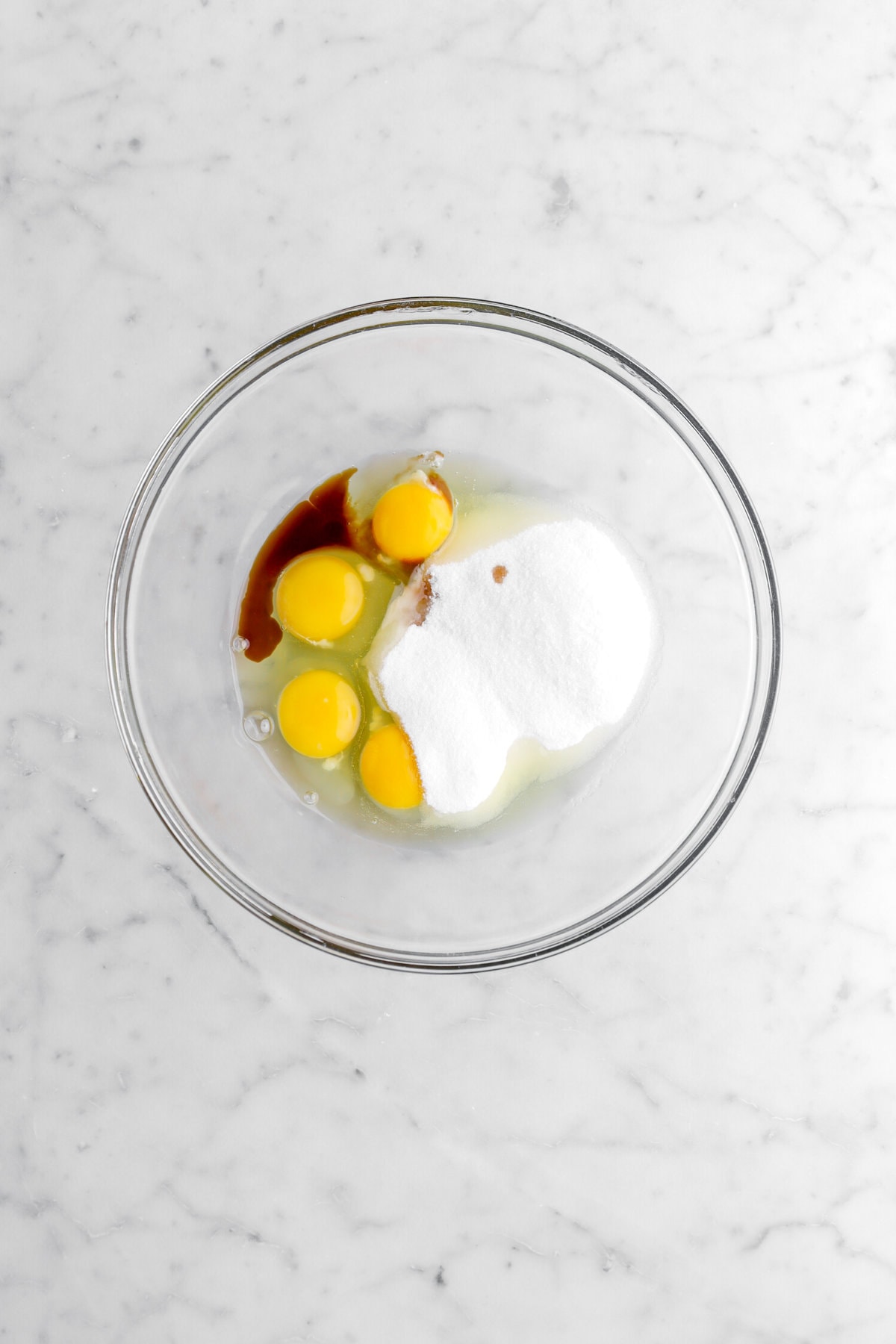 sugar, eggs, and vanilla in glass bowl.