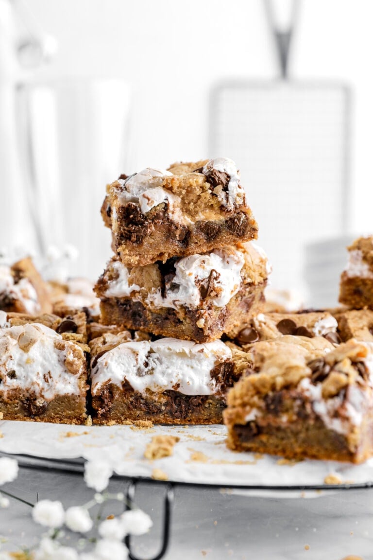 close up of stacked s'mores cookie bars with more bars around.