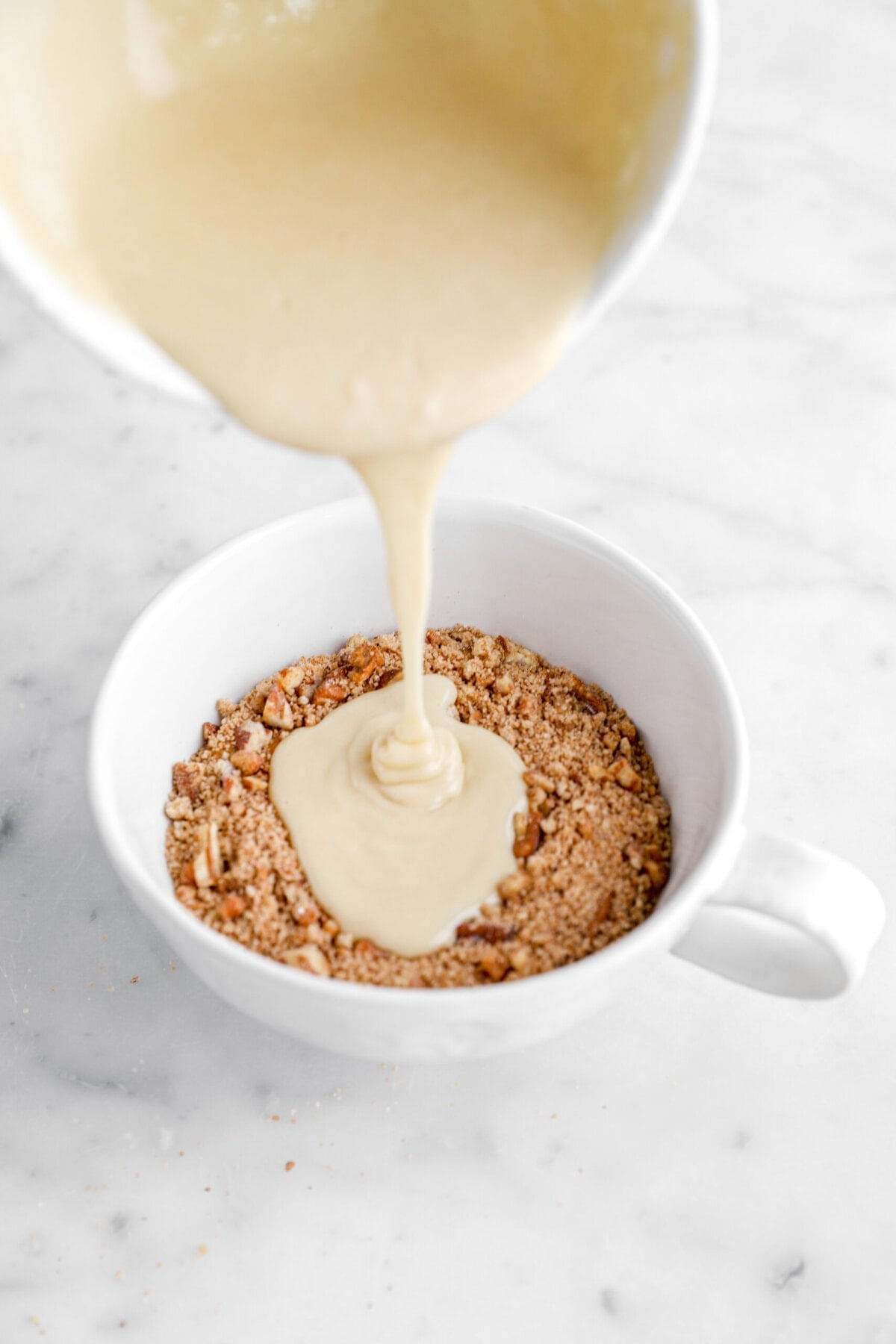 cake batter being poured over streusel.