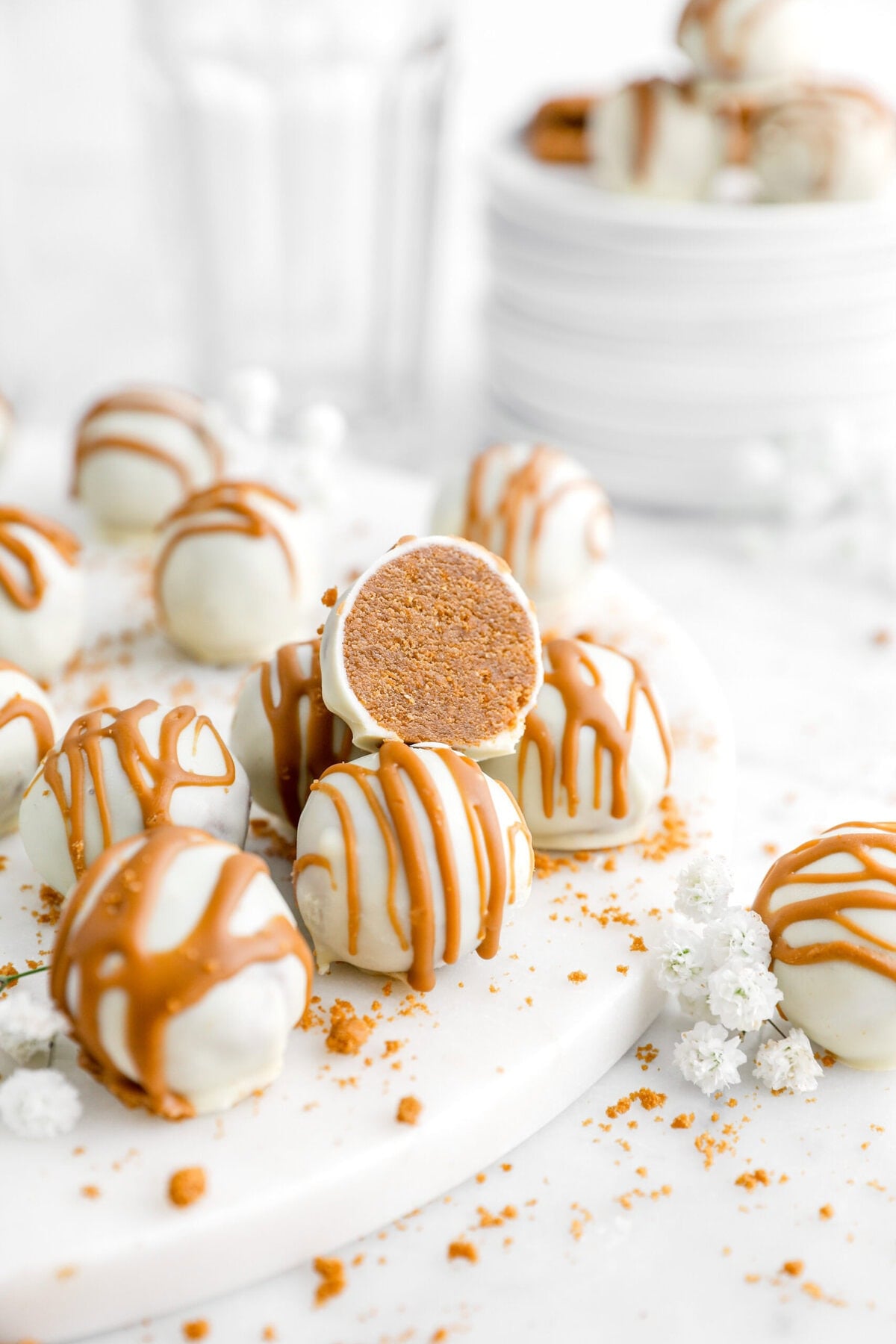 pile of biscoff truffles on marble surface with top truffle cut in half.