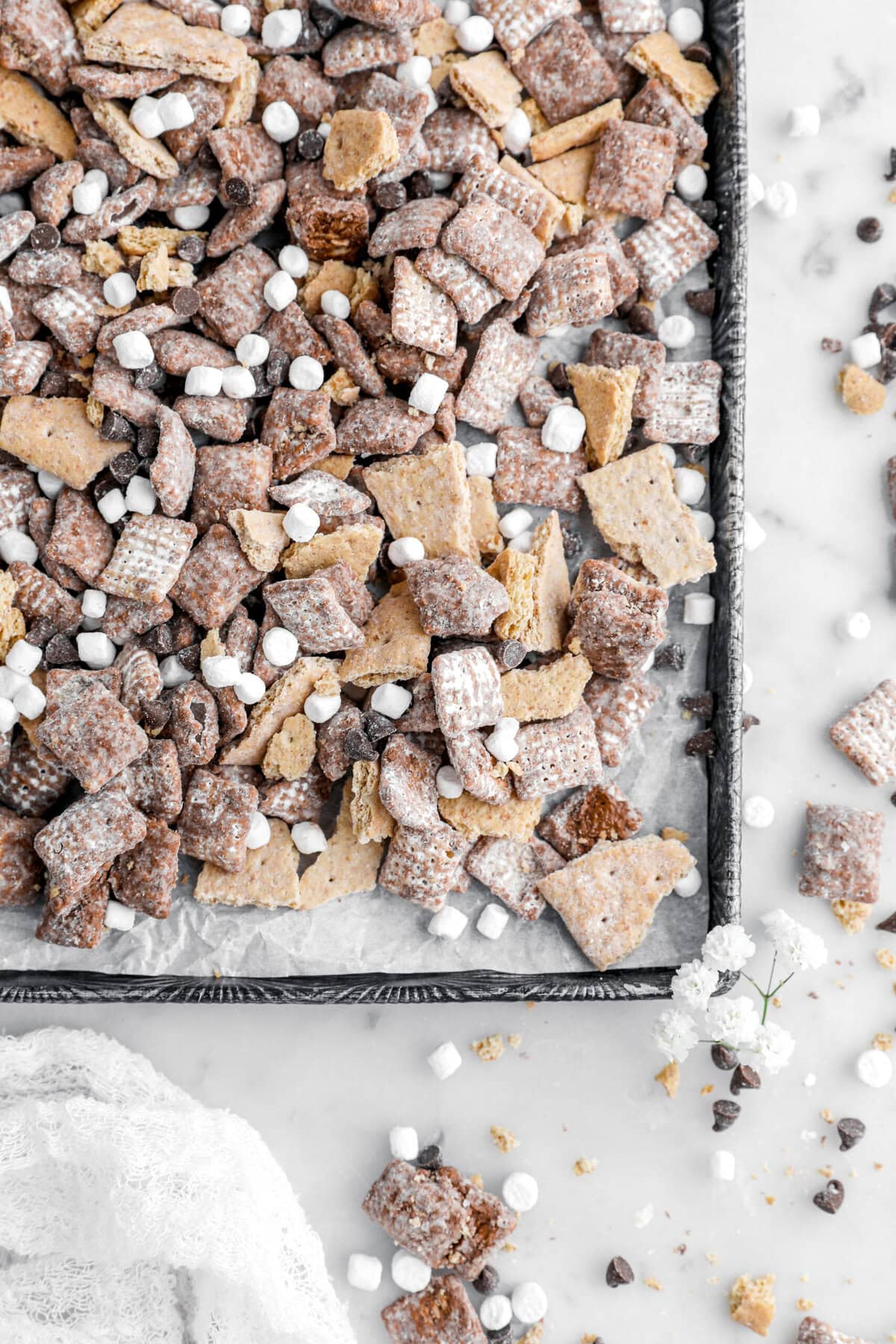 close up of s'mores snack mix on lined baking sheet.